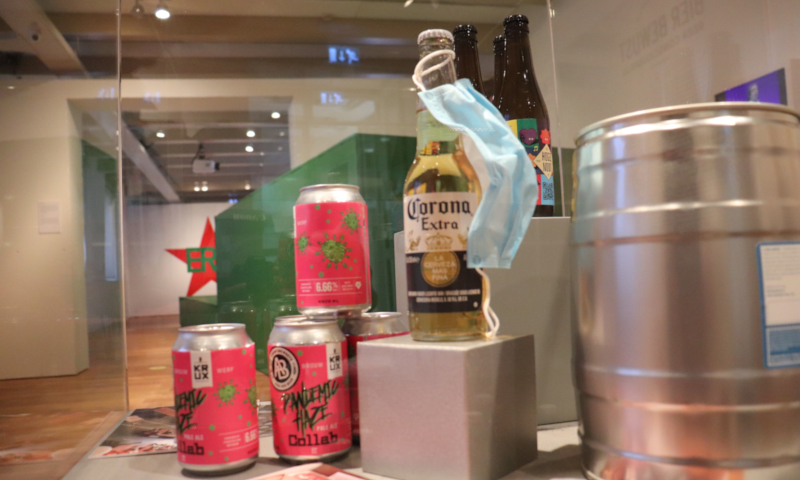 Amsterdam Museum: corona bier met een mondkapje en andere fusten en blikjes bier